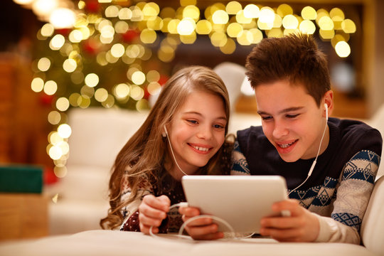 Brother and sister listen music together at Christmas holiday