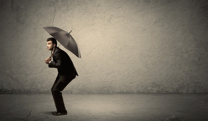 Handsome business man holding umbrella with copy space background