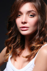 Naklejka premium Portrait of beautiful young woman face. Isolated on dark background.