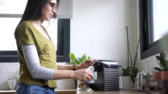 Brunette girl making expresso from coffee machine