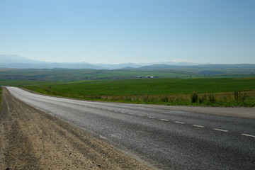 Fototapeta na wymiar Asphalt road among the fields