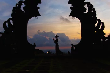 Fotobehang Silhouette of woman full length at the balinese traditional gates at the top of Pura Besakih at sunset. © yolya_ilyasova