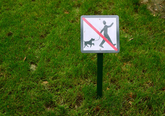 Sign prohibiting dogs walking on the lawn in the city