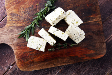 Butter with thyme and rosemary and lemon zest. Sliced on a wooden board with herbs