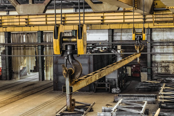Steel hooks with linear traverse of industrial overhead crane in the span of the workshop - obrazy, fototapety, plakaty