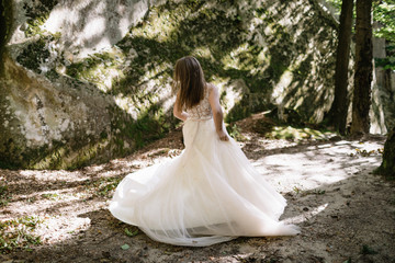 Beautiful stylish bride walking in the forest
