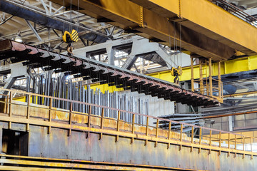 Production process of galvanized steel metal products. Lifting of metal products by overhead crane...