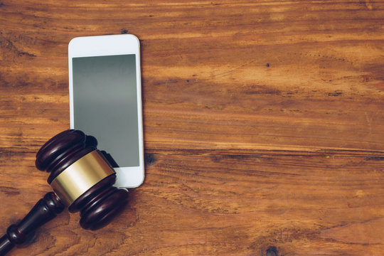 Judge gavel over smartphone, top view