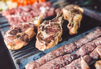 Large pieces of pickled meat on a grid in a restaurant. Mixed grilled meats.