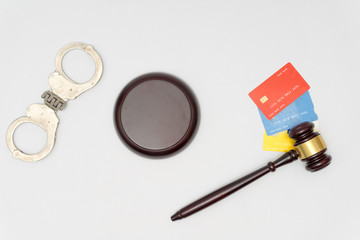 Handcuffs and judge gavel,  and credit cards on white background
