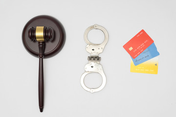 Handcuffs, judge gavel and credit cards on white background