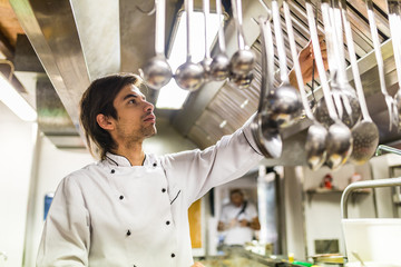 Chef in the kitchen taking a ladle spoon