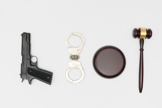 Judge gavel, handgun and handcuffs on white background