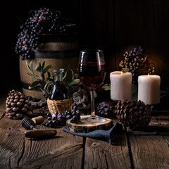 Red wine from a barrel with grapes and a glass of wine