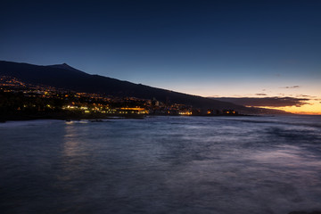 Scenic sunset view of Punta Brava down Playa Maria Jimenez beach with Pico del Teide volcano in the background, the highest point above sea level in the Canary Islands