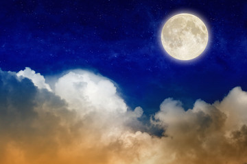 Fototapeta na wymiar Full moon rising above glowing clouds in night sky