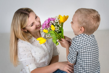 Fototapeta na wymiar Son gives his beloved mother a beautiful bouquet of tulips.The concept of the celebration,women's day.