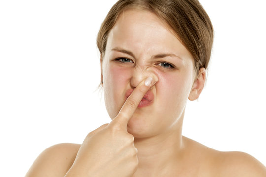 A young woman press her nose with her finger