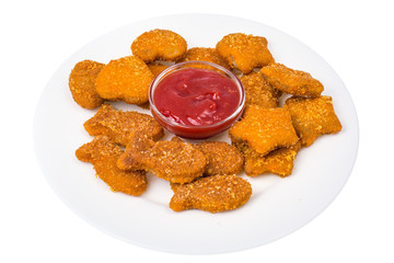 Nuggets of different shapes with ketchup on white background