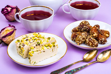 Oriental sweets-halva and dates on bright pink background