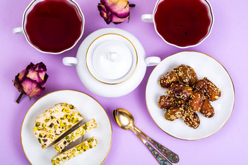 Oriental sweets-halva and dates on bright pink background