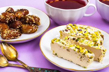 Oriental sweets-halva and dates on bright pink background