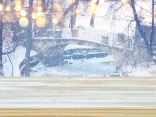 Empty wooden table in front of dreamy and magical winter landscape background. For product display montage.