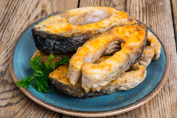 Pieces of fried fish on blue plate