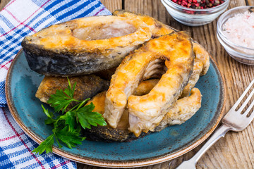 Pieces of fried fish on blue plate