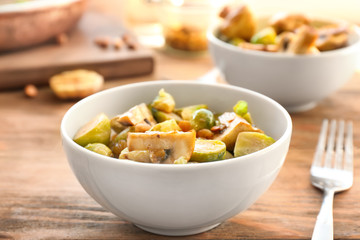 Bowl with yummy brussel sprouts salad on wooden table