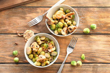Bowls with yummy brussel sprouts salad on wooden table