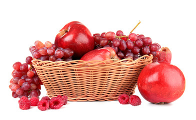Wicker basket with different red fruits and berries on white background