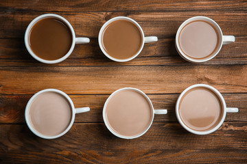 Cups with delicious coffee on wooden background