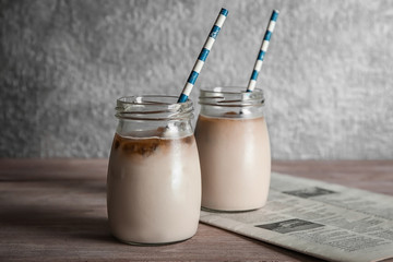 Glass jars with delicious iced coffee on table
