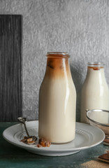 Bottle with delicious iced coffee on table