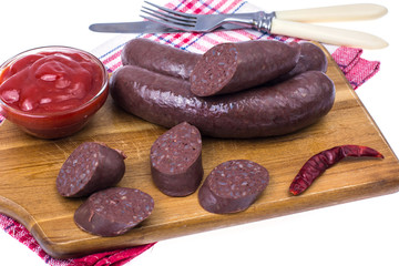 Homemade blood sausage with tomato sauce on wooden board