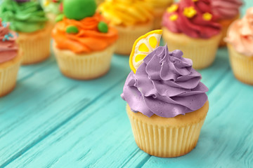Tasty colorful cupcake on wooden background