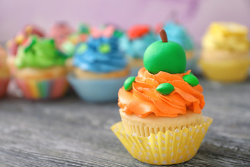 Tasty colorful cupcake on wooden table