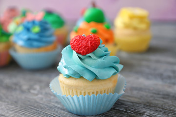Tasty colorful cupcake on wooden table