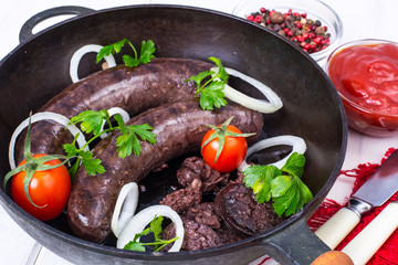 Hot blood sausage with onion on pan