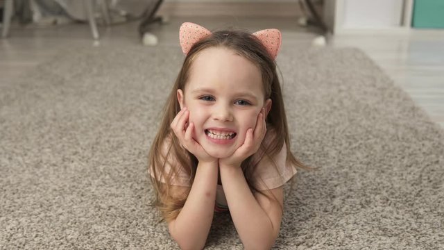 Cute little girl smiling while lying on the floor