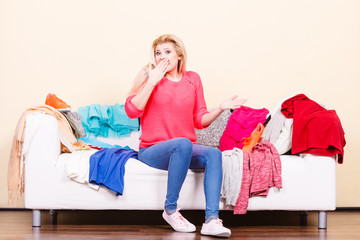 Woman does not know what to wear sitting on couch