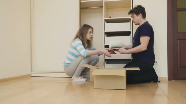 Couple pack things into box for relocation from house