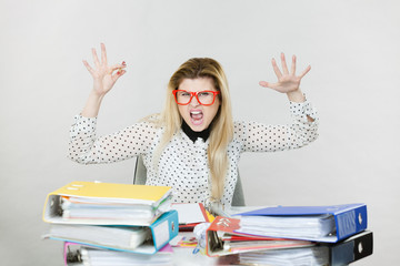 Depressed angry businesswoman sitting at desk