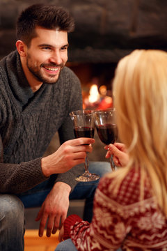 winter holidays and people concept - romantic couple drink wine.