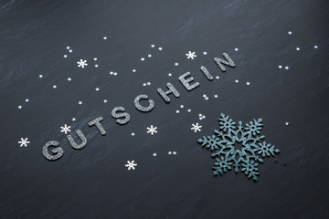 GUTSCHEIN silber glänzende Schrift mit grossem türkis Schneekristall und Sternen auf schwarzem...
