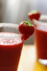 Roter Erdbeer-Smoothie mit Dekoration am Glas