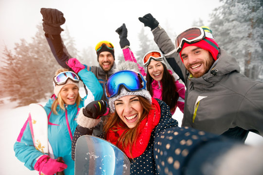 Group of cheerful friends with ski on winter holidays - Skiers having fun on the snow