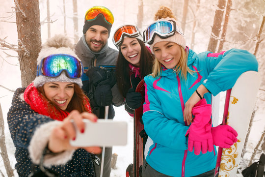 snowboarders or skiers making selfie in fog forest