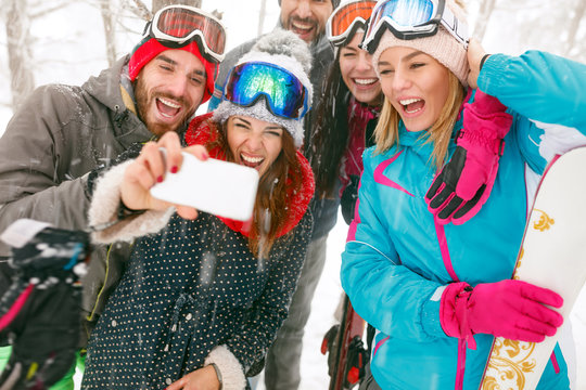 young snowboarders or skiers making selfie in fog forest